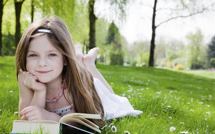 Cute petite fille dans l'herbe, livre lu Fonds d'écran, image